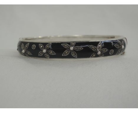 A white metal hinged bangle stamped 925 having black enamel and marcasite floral decoration