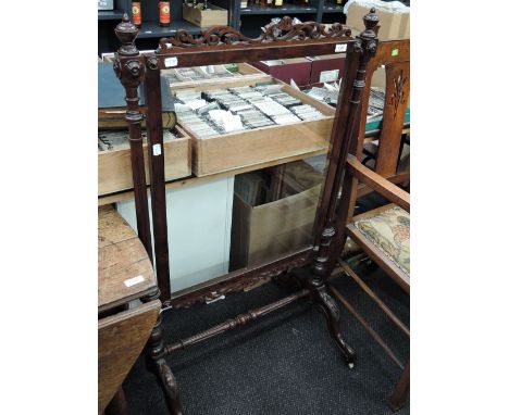 A Victorian mahogany firescreen frame of scroll design, on splay legs