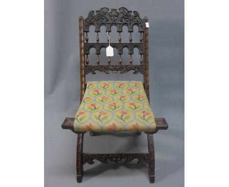 A 19th Century chip carved folding chair having tapestry seat