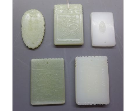 Five Chinese jade pendants each depicting various scenes.