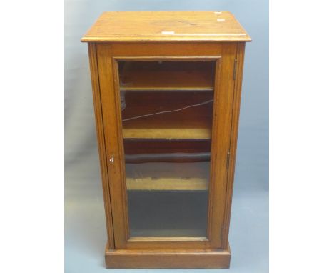 A 19th century oak display cabinet with glazed door enclosing shelf space and raised on stepped base. H-103cm W-55cm D-40cm.