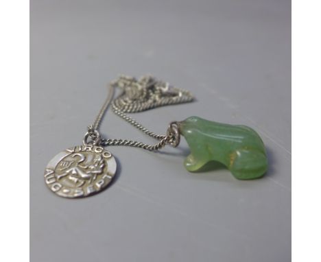 A small jade pendant in the form of a frog on a silver chain