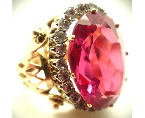 Grecian presumed (unmarked) 14ct gold dress ring, having a large oval cut pink sapphire, approximately 19 x 13 mm, surrounded