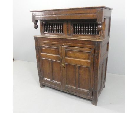 An 18th century panelled oak court cupboard, with bobbin turned and carved decoration. Width 110cm, height 131cm, depth 55cm.