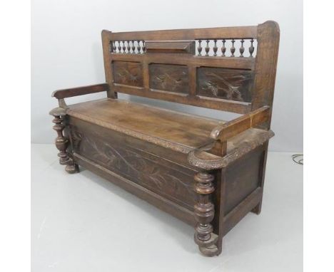 A Breton French panelled oak hall bench, with lifting seat and carved decoration. W127, 90, 50cm.