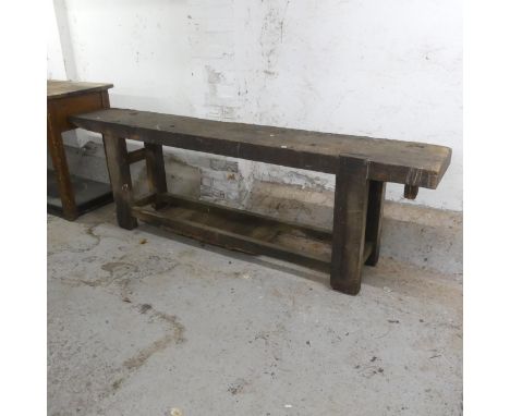 An antique stained pine two-tier work bench. Width 242cm, height 76cm, depth 40cm.