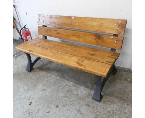 A pine garden bench on cast iron frame. Length 138cm, height 77cm, depth 60cm.