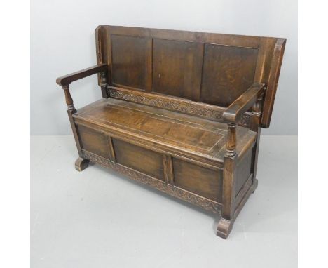 An early 20th century panelled oak monk's bench with applied carved decoration. Dimensions as table - Length 130cm, height 72