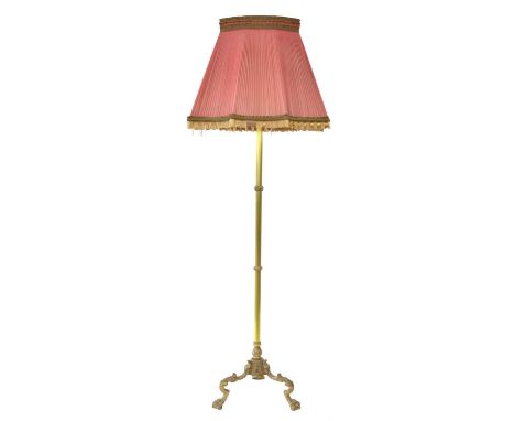 Brass standard lamp and shade Brass standard lamp and shade, reeded gilt brass column on a cast tripod base with floral decor