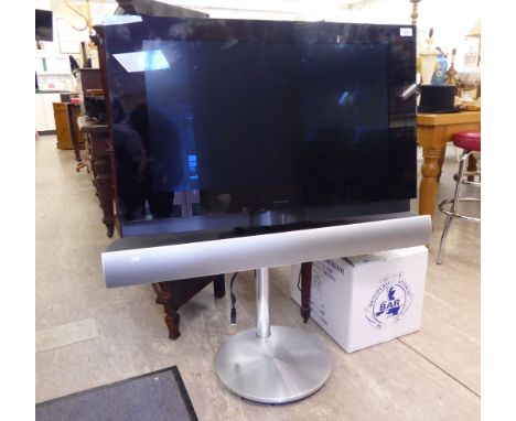 A Bang & Olufsen BeoVision 7  31'' television with integral speaker, on a plinth with a remote control        RAB