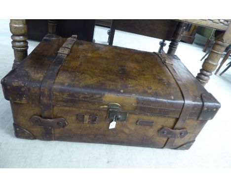 An early 20thC stitched brown hide cabin trunk with straight sides and a hinged lid, enclosing a removable tray interior, bea