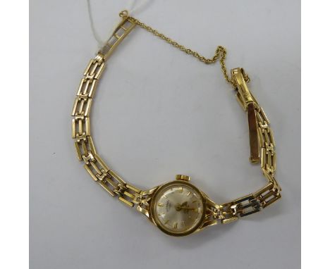 A lady's Rotary 9ct gold round cased wristwatch, on a gatelink bracelet, faced by a baton dial       11