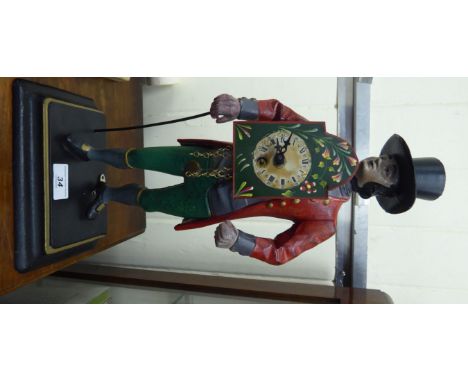A 'vintage' Dutch painted cast metal novelty 'clock seller' mantel timepiece, a standing man, wearing a red coat, green breec