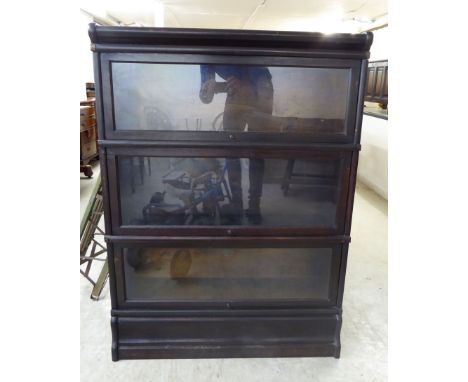 An early 20thC Globe Wernicke painted oak bookcase with three glazed sections, on a plinth  46''h  34''w       BSR