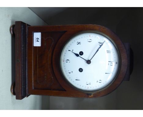 An early 20thC mahogany, round arched cased mantel clock with a domed top and cast gilt metal flank handles and grilles, on a