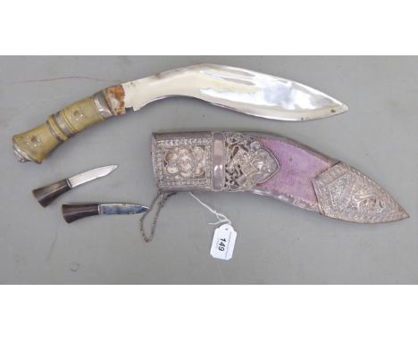 An early 20thC kukri with a two part horn handle, the scratch engraved blade 11''L in a moulded fabric covered and white meta