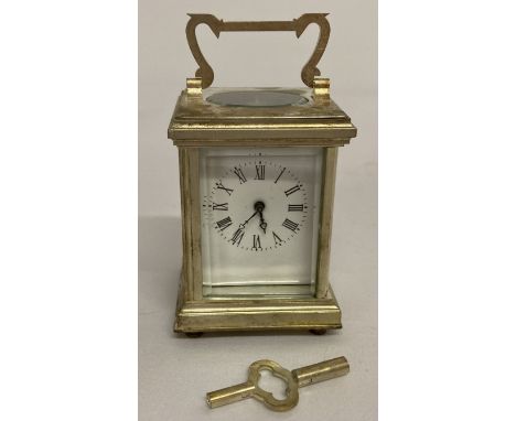 A small modern silver plated carriage clock with enamelled face and bevel edged glass panels.  Complete with key. In working 