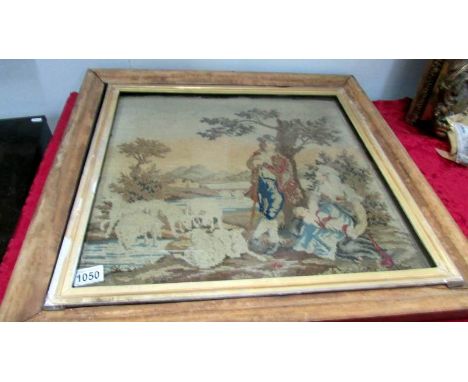 A framed and glazed 19th century tapestry of a shepherd, wife and baby with sheep, size including frame 26'' x 25''