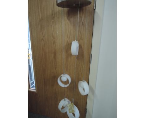 A large ceiling light with ceramic drop hoops