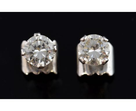 A pair of diamond earrings, set with a round brilliant cut diamond weighing approximately 0.75cts each four claw setting..   