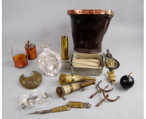 A collection of miscellaneous military items including leather fire bucket, grenade cigar lighter, horn powder flasks, grenad