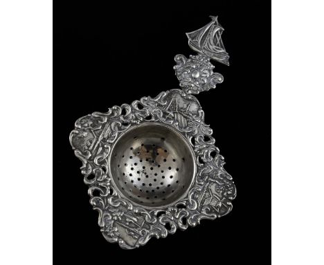 A Dutch silver tea strainer with ship finial, the bowl chased with further scenes, 13 cm long, 41 gr..   