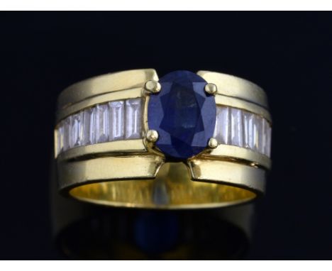 Sapphire and diamond ring, central stone in raised setting, and a band of baguette cut diamonds,18 ct gold, ring size K 1/2 .