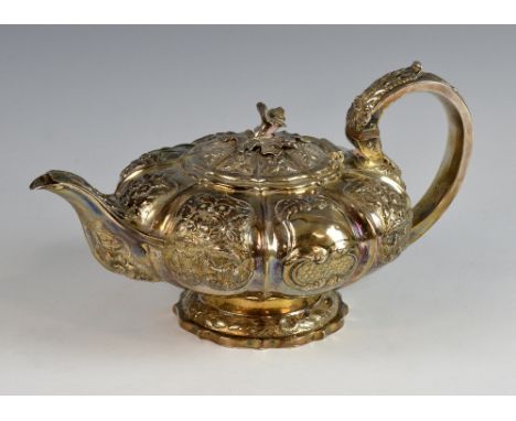 George IV silver melon shaped teapot with embossed and moulded decoration on shaped foot, by Richard Pearce & George Burrows,