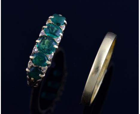 Emerald ring in carved setting with small diamonds, ring size K 1/2  and a gold wedding band, ring size O .   The emerald rin