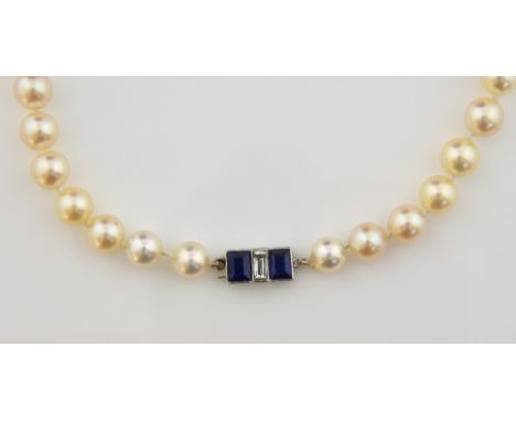 Art Deco pearl necklace with a sapphire and diamond clasp. the cultured pearls measuring approximately 6.5 to 7.5mm with knot