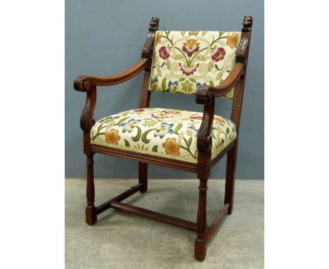 Gothic style mahogany framed armchair with lion mask and leaf capped terminals to top supports with tapestry stuff over seat 