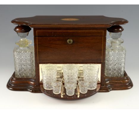 Early 20th century mahogany two decanter tantalus with locking rising cover, and central swivel out glasses compartment, 29cm
