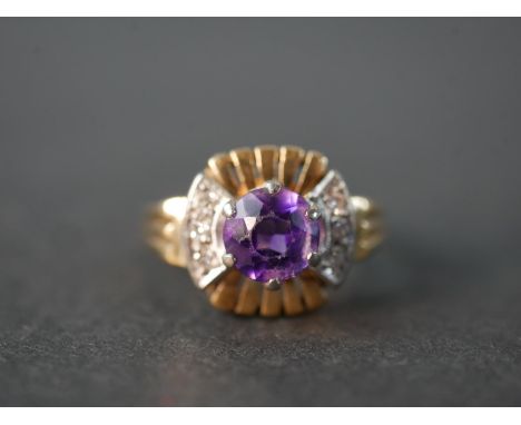 A vintage 14 carat white and yellow gold amethyst and diamond dress ring, set to centre with a round mixed cut amethyst with 