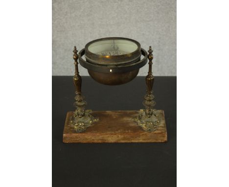 A Victorian brass gimbal mounted ships compass by F.M. Moore of Dublin and Belfast, with cast brass supports mounted on a woo