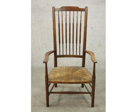 A beech stick back country armchair, with a woven seat, the legs joined by stretchers. 