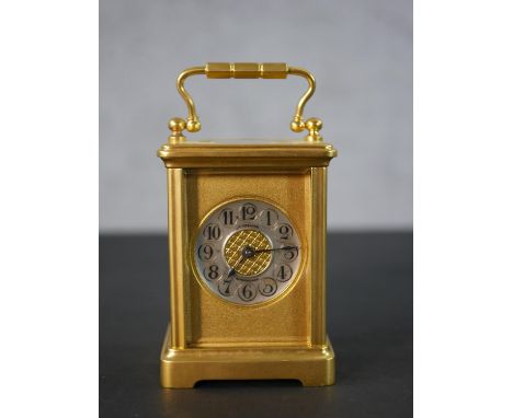 A late Victorian gilt brass cased carriage clock, circular chapter ring with, numerals, the gilt metal surround named H. Grea