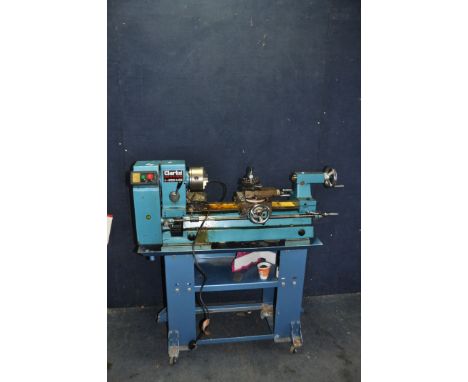 A CLARKE METALWORKER 6 speed lathe on stand with a three jaws chuck , 68cm bed, and some tools inside stand(PAT fail due to g
