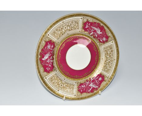 A MINTON PATE SUR PATE PLATE, DECORATED WITH THREE PANELS OF AN EXOTIC BIRD AMONGST FOLIAGE ON A CLARET GROUND, one panel sig