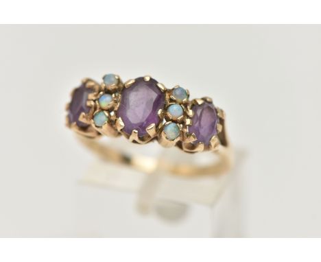 A 9CT GOLD AMETHYST AND OPAL RING, set with three oval cut amethysts each claw set, interspaced with six small circular cut o
