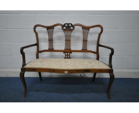 A VICTORIAN MAHOGANY SOFA, with wavy top and scrolled crest, three splat back supports, shaped open arm rests, on front cabri