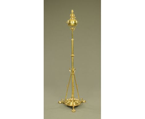 A 19th century brass lamp standard, converted to electricity and with three angled supports terminating in paw feet.  Height 