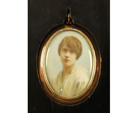 A 9 ct gold oval locket, initialled and housed in an ebonised frame, the locket reverse with portrait miniature.