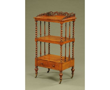 A Victorian walnut three tier whatnot stand, with fretwork gallery and single drawer raised on short turned legs terminating 