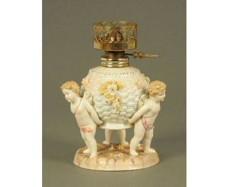 A Sitzendorf oil lamp base, three cherubs holding the reservoir.  Height 21 cm. CONDITION REPORT: The burner is glued in posi