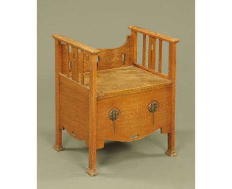 An Arts &amp; Crafts oak commode, with stylised carving.  Width 54.5 cm.
