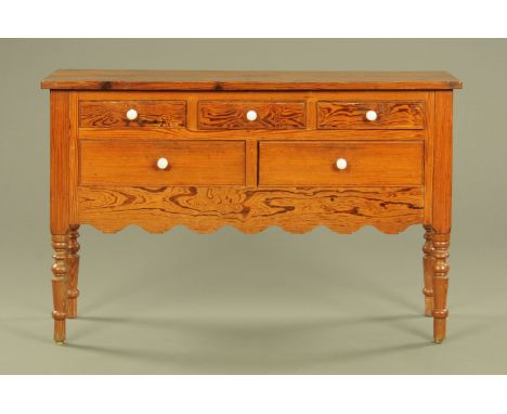 A 19th century pitch pine dresser base, fitted with a series of five drawers with ceramic knob handles, with shaped apron and