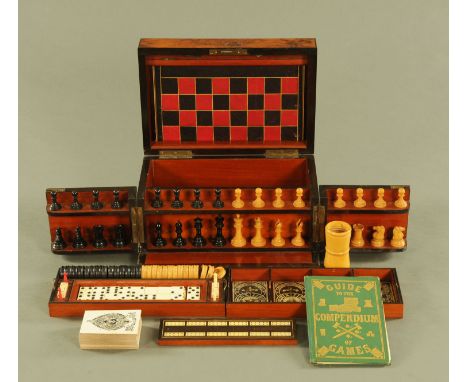 A Victorian walnut cased games compendium, opening to chess men, draughts, cribbage, dominoes.  Width 32.5 cm (see illustrati