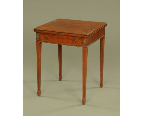 An Edwardian mahogany square envelope card table, with frieze drawer bearing plaque for Heals and raised on tapered legs of s
