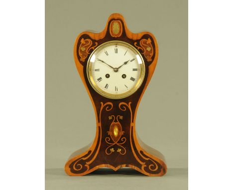An Edwardian Art Nouveau inspired shaped mantle clock, inlaid with mother of pearl and boxwood and with two train striking mo