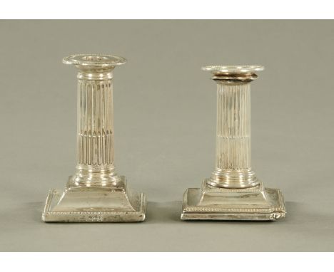 A pair of Mappin &amp; Webb silver candlesticks, with fluted columns and beaded square stepped bases.  Sheffield mark 1906.  